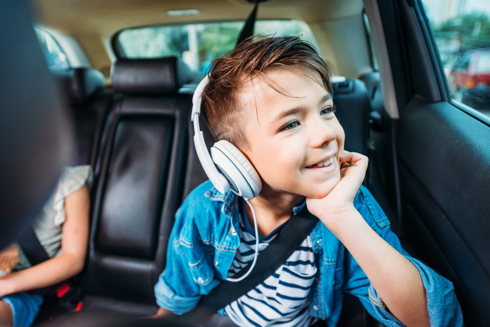 un enfant dans la voiture écoute un livre audio